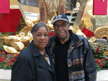 a man wearing a ny hat stands next to a woman in a black coat