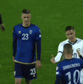 soccer players number 23 and 10 hugging each other on the field