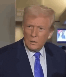 donald trump is wearing a suit and tie and is making a funny face .