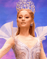 a woman wearing a crown and a white dress is smiling