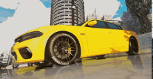 a yellow dodge charger is parked in front of a tall building