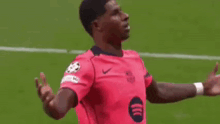 a soccer player in a pink shirt is standing on a soccer field .