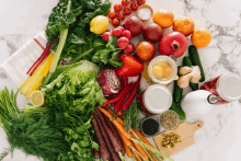 a variety of fruits and vegetables on a table including carrots