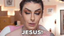 a woman is making a funny face with her eyes closed and the words jesus written on her face .