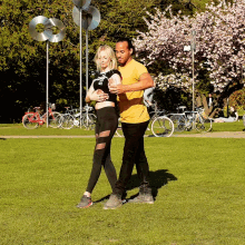 a man in a yellow shirt is hugging a woman who is wearing a black shirt that says " i love you " on it