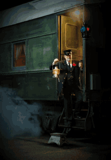 a man holding a lantern is standing in front of a train car