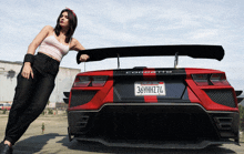 a woman leans against a red corvette with a california license plate