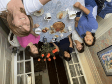 a group of women sitting around a table with food