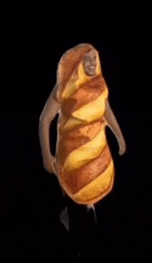 a person dressed as a loaf of bread is dancing .