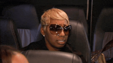 a woman wearing sunglasses is sitting in a car seat
