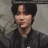 a close up of a person with a microphone and the words tomorrow x together