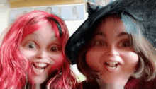 two girls with red hair and black hats are posing for a picture together