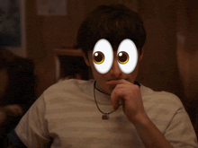 a man wearing a necklace and a striped shirt has cartoon eyes on his face