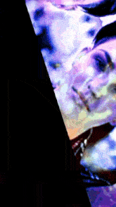 a close up of a woman 's face with a purple and blue background
