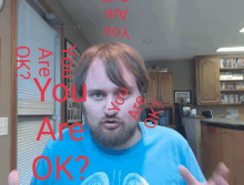 a man wearing a blue shirt with the words " are you ok " on it