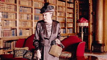 a woman is standing in front of a bookshelf in a library holding a purse
