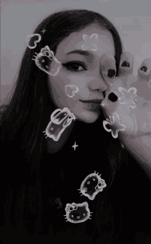 a black and white photo of a girl with hello kitty bubbles on her face