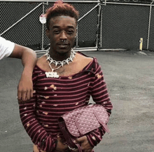a man in a striped shirt holds a pink bag