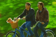 two men are riding a tandem bicycle with a basket on the back .