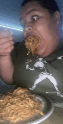 a man wearing a shirt with a baseball player on it eats noodles