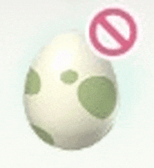 a white egg with green polka dots is sitting next to a no sign .