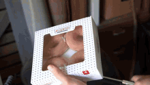 a person holding a box of krispy kreme donuts in their hand