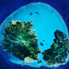 an aerial view of a small island in the middle of a large body of water