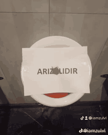 a white plate with a piece of paper that says arizalidir on it