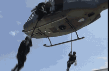 a man is hanging from a rope from a helicopter with the letters u.s. on it