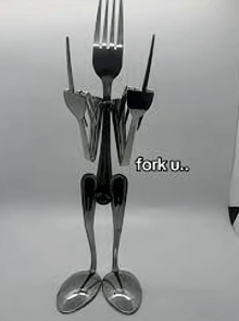 a statue made out of forks and spoons says fork u..
