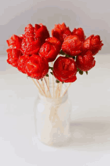 a bouquet of strawberries on sticks in a mason jar