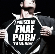 a man in a suit is holding a shirt that says i paused my fnaf porn to be here