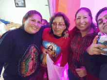 a group of people posing for a picture with one woman wearing a red shirt with jesus on it