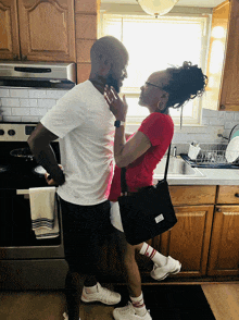 a man and a woman are standing in a kitchen