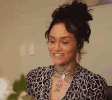 a woman with a tattoo on her neck is smiling and looking at the camera .