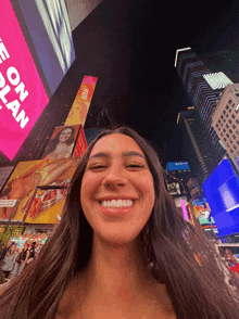 a woman is smiling in front of a sign that says ' e on plan '