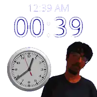 a man stands in front of a wall clock that says 12:39 am