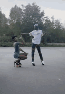 a man and a woman are dancing on a street .