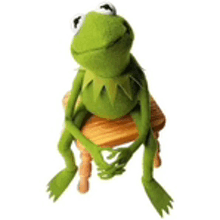 kermit the frog is sitting on a chair with his legs crossed