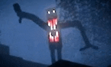 a cartoon character with a huge mouth is standing in the dark with its arms outstretched .