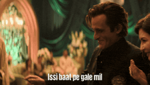a man and a woman are standing in a room with the words issi baat pe gale mil on the bottom