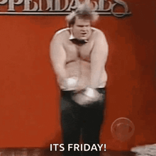a man without a shirt is dancing in front of a red wall with the words `` it 's friday '' .