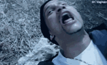 a man is laying on the ground with his mouth open and his eyes closed .