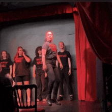 a woman in a netflix t-shirt is dancing on stage