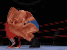 a man in a blue underwear is wrestling another man in a red shirt