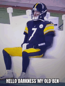 a football player with the number 7 on his jersey sits on the sidelines