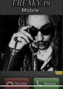 a phone screen shows a man with dreadlocks talking on the phone