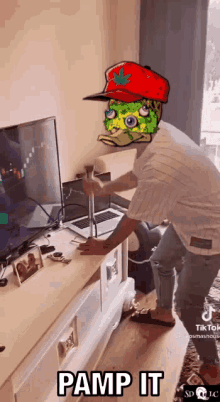 a man wearing a spongebob hat is standing in front of a tv holding a hammer .