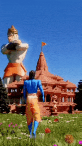 a man in a blue shirt is walking in front of a temple with a statue of hanuman in the background .