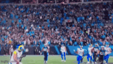 a football game is being played in a stadium with a large crowd watching .